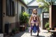 A woman in a purple and blue outfit standing in front of a house.