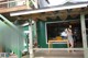 A woman standing on a porch with a laptop computer.