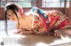 A woman in a kimono laying on the floor.