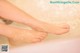 A woman's feet in a bathtub filled with water.