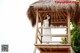 A woman in a white dress standing on a wooden structure.