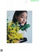 A woman holding a bunch of yellow flowers.